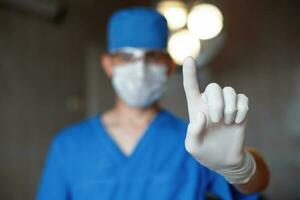 Doctor warns of danger and shows the index finger. The surgeon informs the warning. photo