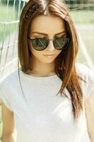 retrato de un hermosa niña en Gafas de sol en un verano soleado día. foto