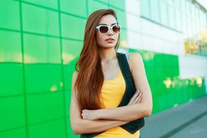 Stylish beautiful girl in sunglasses in a yellow t-shirt is hand in hand. photo