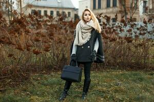 hermosa joven rubia mujer en un elegante otoño Saco con un negro bolso Moda foto