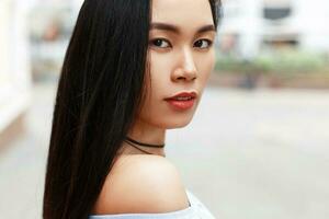 outdoors portrait of a beautiful Asian girl on the background of the city. photo