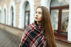 Beautiful girl in a vintage striped scarf on the street photo