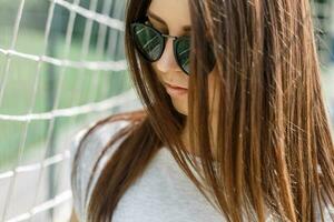 de cerca retrato de un joven hermosa mujer en elegante Moda Gafas de sol en el verano soleado día. foto