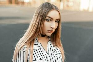 Beautiful young woman with an earring in the nose in a striped blouse photo