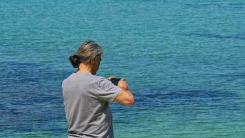 Traveling Man Taking Ocean Photo with Mobile Phone video