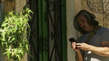 Traveling Man Making Video Call with Mobile Phone Next to Green Iron Antique Door