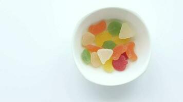 child hand pick colorful candy sweet jelly in a bowl on table video