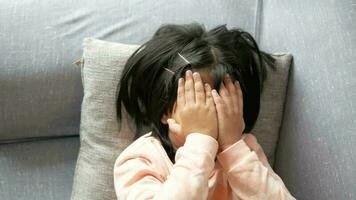 en upprörd barn flicka omslag henne ansikte med hand video