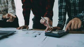 Image of engineering objects on workplace with three partners interacting on background video