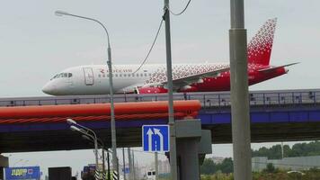 MOSCOW, RUSSIAN FEDERATION JULY 29, 2021 - Plane of Rossiya drive over Sheremetyevskoe highway. Bridge for aircraft from the new runway to the terminal of Sheremetyevo Airport SVO video