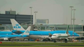 Amsterdam, de Nederland juli 27, 2017 - alitalia taxiën Aan de vliegveld van Amsterdam luchthaven. klm luchtvaartmaatschappijen vliegtuig in de achtergrond. reizen concept video