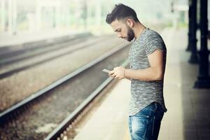 joven hombre a el tren estación. foto