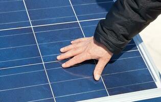 Hand on solar panel photo