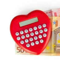 Red heart shaped calculator with euro banknotes. photo