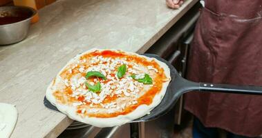 Raw margherita pizza on baking shovel. photo