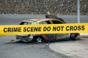 American police tape barricading a burnt car photo