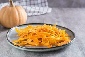 Appetizing vegetarian dessert pumpkin chips on a plate on the table photo