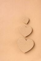 Family concept. Three cardboard hearts - dad, mom and baby on a beige background. Top and vertical view. photo