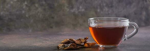 Homemade hot tea from dried mushrooms in a cup on the table web banner photo