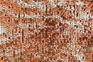 Textured gold background from round sequins on black fabric. Top view photo
