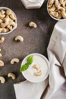 Fresh cashew sauce with basil in a bowl for a vegetarian diet top and vertical view photo