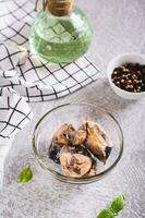Pieces of canned tuna in a glass bowl on the table vertical view photo