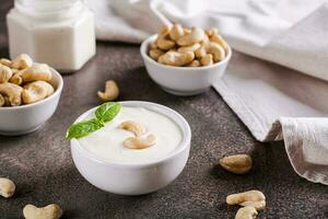 Vegan cashew sauce in bowl with basil on table for plant based diet photo