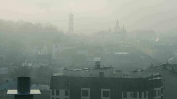 historisch centrum van lviv in dicht mist. silhouetten van gebouwen en daken van huizen. Oekraïne video