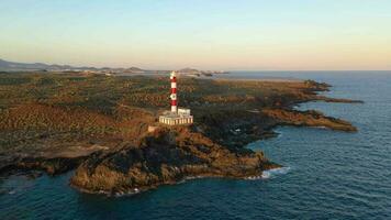 aéreo Visão do a farol faro de rasca, natureza reserva e a montanhas às pôr do sol em tenerife, canário ilhas, Espanha. selvagem costa do a atlântico oceano. video