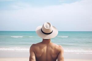 espalda ver de un hombre vistiendo un sombrero sentado en un playa. ai generado foto