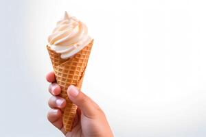 Hand holding delicious vanilla ice cream in a crispy waffle cone with copy space. photo