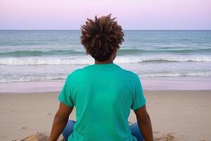 Back view of a man sitting on a beach. photo