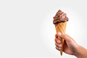 Hand holding delicious chocolate ice cream in a crispy waffle cone with copy space. photo