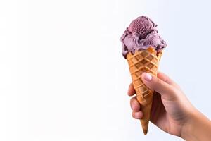 Hand holding delicious blueberry ice cream in a crispy waffle cone with copy space. photo