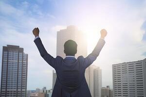 Successful businessman raising hand and expressing positivity while standing against skyscrapers background. photo