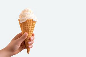 Hand holding delicious vanilla ice cream in a crispy waffle cone with copy space. photo