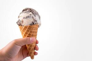 Hand holding delicious cookies and cream ice cream in a crispy waffle cone with copy space. photo