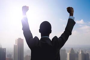 Successful businessman raising hand and expressing positivity while standing against skyscrapers background. photo