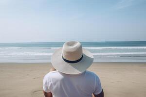 espalda ver de un hombre vistiendo un sombrero sentado en un playa. ai generado foto