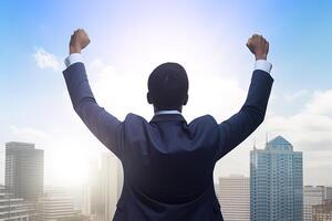 Successful businessman raising hand and expressing positivity while standing against skyscrapers background. photo