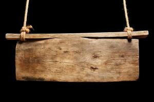 Wooden sign plain hanging from rope isolated on black background. photo