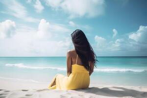 Back view of a woman sitting on a beach. photo