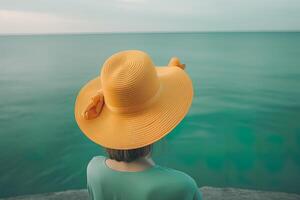espalda ver de un mujer vistiendo un sombrero sentado en un playa. ai generado foto