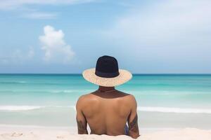 espalda ver de un hombre vistiendo un sombrero sentado en un playa. ai generado foto