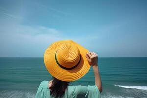 espalda ver de un mujer vistiendo un sombrero sentado en un playa. ai generado foto