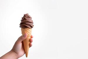 Hand holding delicious chocolate ice cream in a crispy waffle cone with copy space. photo