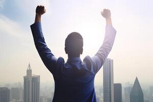 Successful businessman raising hand and expressing positivity while standing against skyscrapers background. photo