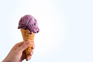 Hand holding delicious blueberry ice cream in a crispy waffle cone with copy space. photo