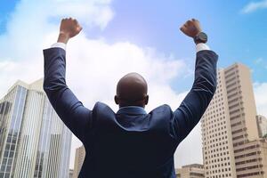 Successful businessman raising hand and expressing positivity while standing against skyscrapers background. photo