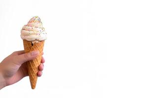 Hand holding delicious sprinkles ice cream in a crispy waffle cone with copy space. photo